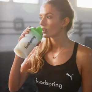 mujer tomando batido sustitutivo en un shaker