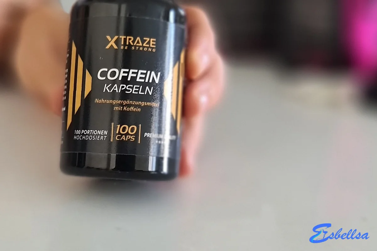 Bote de Xtraze Coffein Kapseln en la mano, con dos cápsulas delante