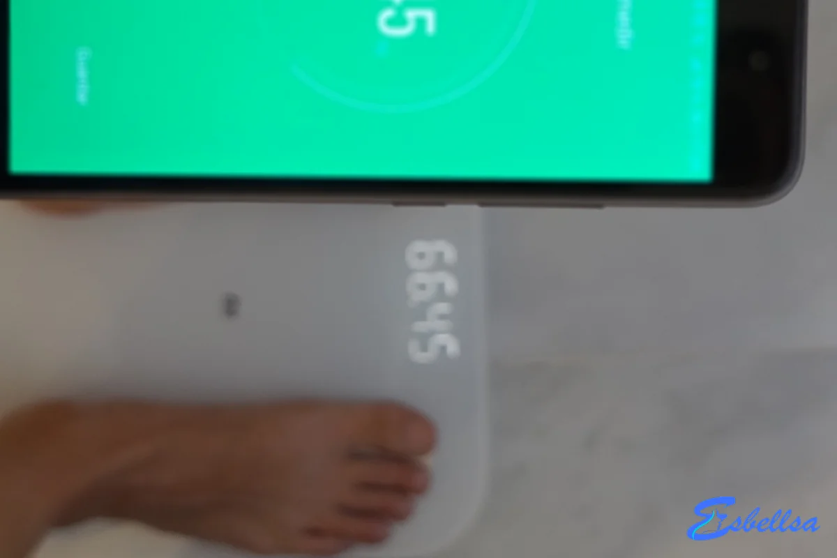 Movil mostrando 66,45 kg junto a la bascula que marca lo mismo, durante una de nuestras pruebas