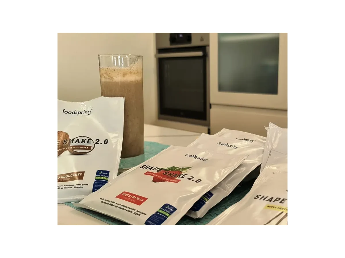 Sobres de FoodSpring Shape Shake 2.0 y el batido preparado