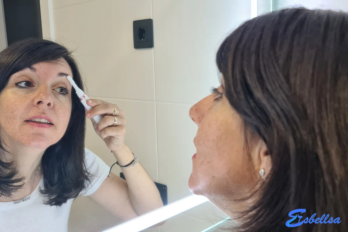 perfilando las cejas con la philips satin compact frente al espejo